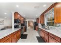 Modern kitchen with sleek marble countertops, wood cabinets, black appliances, and stylish backsplash at 7205 June Bug Ln, Orlando, FL 32818