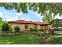 View of single-story home with terracotta roof, tidy landscaping and a well-manicured lawn at 8143 Terragona Ct, Orlando, FL 32836