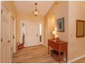 Bright foyer with wooden floors, a white front door, and warm, neutral tones at 8143 Terragona Ct, Orlando, FL 32836