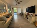 Inviting living room showcasing hardwood floors, neutral walls, comfortable seating, and a sliding glass door at 932 S Lake Sterling Ct, Casselberry, FL 32707