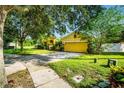 Inviting home exterior featuring a well-kept lawn, mature trees, and a two-car garage at 969 Springs Landing Dr, Deltona, FL 32725