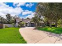 Inviting home showcasing lush landscaping, a spacious driveway, and a classic brick and siding facade at 1000 Chesterfield Cir, Winter Springs, FL 32708