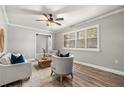 Bright living room with hardwood floors, plantation shutters, and neutral-colored furniture at 126 Duncan Trl, Longwood, FL 32779