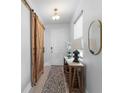 Stylish entryway featuring a sliding barn door, decorative table, and modern decor at 13227 Spring Grove Way, Winter Garden, FL 34787