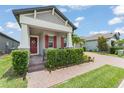Inviting front yard with a brick driveway, manicured bushes, and red shutters, enhancing curb appeal at 13227 Spring Grove Way, Winter Garden, FL 34787