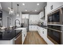 Modern kitchen features white cabinets, stainless steel appliances, and black countertops at 1341 Lumpini St, St Cloud, FL 34771