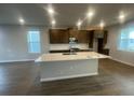 Modern kitchen with stainless steel appliances, an island with sink, and dark wood cabinets at 1354 Twelve Oaks Rd, St Cloud, FL 34771