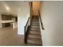 Staircase featuring wood treads, a dark wood handrail, and access to the upper level at 1354 Twelve Oaks Rd, St Cloud, FL 34771
