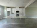 Bright kitchen featuring white cabinets, a functional center island with sink, and modern finishes at 1411 Mount Royal Dr, St Cloud, FL 34771
