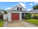 Charming home with a red garage door, inviting front porch, and lush landscaping at 1413 Brookebridge Dr, Orlando, FL 32825