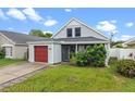 Charming home with a red garage door, inviting front porch, and lush landscaping at 1413 Brookebridge Dr, Orlando, FL 32825