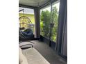 Relaxing screened porch area featuring a hanging chair and tranquil views of the surrounding foliage at 1413 Brookebridge Dr, Orlando, FL 32825