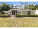 Inviting single-story home featuring arched windows, brick accents, and a well-manicured lawn at 14612 Bray Rd, Orlando, FL 32832