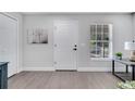 Bright entryway with white door, gray walls, light-colored wood floors, and a window with light-filtering blinds at 1533 Fort Smith Blvd, Deltona, FL 32725