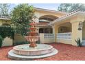 Attractive fountain and red mulch landscaping compliment this two-story home with a red tile roof at 1542 Islay Ct, Apopka, FL 32712
