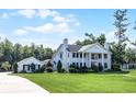 Elegant white home boasts stately columns, black shutters, and meticulously landscaped front yard at 2487 River Tree Cir, Sanford, FL 32771