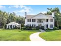 Charming white home with classic columns, black shutters, and a gracefully curved walkway at 2487 River Tree Cir, Sanford, FL 32771