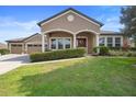 Attractive home featuring an attached three car garage and manicured green lawn at 3551 Statham Dr, Apopka, FL 32712