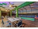 Covered patio with view of pool and lake with outdoor dining furniture and pink flamingo float at 4161 Paragraph Dr, Kissimmee, FL 34746