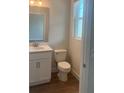 Stylish half bathroom features a modern vanity with quartz countertop, white cabinets, and wood-look tile flooring at 446 Scotsmans Pl, Debary, FL 32713