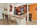 Beautiful kitchen with granite countertops, dark cabinetry, and modern stainless steel appliances and breakfast bar at 5545 Devonbriar Way # 206, Orlando, FL 32822
