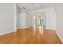 Spacious living room boasting hardwood floors and an archway to the glass front door at 604 Cheviot Ct, Apopka, FL 32712