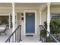 Inviting front entrance featuring a blue door, white columns, and a cozy seating area at 676 Dunblane Dr, Winter Park, FL 32792