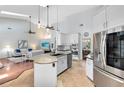 Spacious kitchen with white cabinets, stainless steel appliances, an island with granite countertops, and open to the living room at 718 Glen Eagle Dr, Winter Springs, FL 32708
