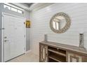 Bright foyer featuring tile flooring, a stylish accent wall, and a modern console table with a decorative mirror at 731 Arbor Pointe Ave, Minneola, FL 34715