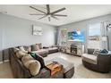 Spacious living room with a large sectional sofa, tile flooring, a ceiling fan, and a modern fireplace at 731 Arbor Pointe Ave, Minneola, FL 34715