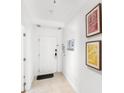 Clean hallway with neutral decor, tiled floors, and contemporary wall art at 7650 Whisper Way # 104, Reunion, FL 34747