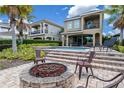 Paver patio with a fire pit and lounge chairs, overlooking the in-ground pool and lush backyard landscaping at 796 Desert Mountain Ct, Reunion, FL 34747