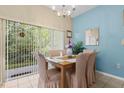 Cozy dining area with chandelier lighting and a large window overlooking a lush exterior at 8507 Crystal Cove Loop, Kissimmee, FL 34747