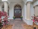 Inviting entryway featuring double doors, decorative wreaths, and elegant columns at 8531 Cypress Hollow Ct, Sanford, FL 32771