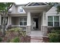 Inviting front porch with stone pillars and an open door showcasing the home's interior at 8670 Vedder Ln, Orlando, FL 32832