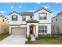 Charming two-story home featuring a well-manicured lawn, a two-car garage, and classic architectural details at 8928 Coconut Breeze Dr, Kissimmee, FL 34747