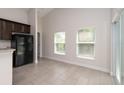 Bright kitchen area with black appliances, a breakfast bar, two large windows, and ceramic tile flooring for easy maintenance at 1206 Beechdale Ct, Deltona, FL 32725
