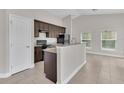 Stylish kitchen with breakfast bar, granite countertops, stainless sink, and tile floors open to a bright dining area at 1206 Beechdale Ct, Deltona, FL 32725