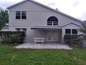 Home's back exterior featuring a nice patio, with white furniture, and an awning at 13200 Mallard Cove Blvd, Orlando, FL 32837