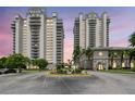 Exterior shot of modern condos and a landscaped entrance with lush greenery, creating an inviting and upscale curb appeal at 13427 Blue Heron Beach Dr # 404, Orlando, FL 32821