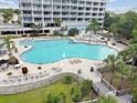 Aerial view of a large community pool surrounded by lush landscaping and comfortable seating, ideal for relaxation and enjoyment at 13427 Blue Heron Beach Dr # 404, Orlando, FL 32821