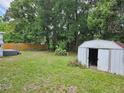 Lush backyard featuring ample greenery and a small storage shed, offering practical storage solutions and outdoor space at 1525 Hilltop Rd, Casselberry, FL 32707