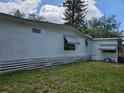 Side view of the single-story home with tidy siding and window awnings, highlighting its well-maintained exterior features at 1525 Hilltop Rd, Casselberry, FL 32707
