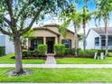 Charming single-story home with a well-manicured lawn, lush landscaping, and inviting front porch at 15647 Braintree Ln, Winter Garden, FL 34787