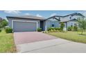Inviting single-story home with a brick driveway, lush green lawn, and a well-maintained exterior at 17363 Million Lakes Ct, Clermont, FL 34714