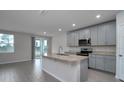 Modern kitchen featuring stainless steel appliances, granite countertops, and a central island with a sink at 17363 Million Lakes Ct, Clermont, FL 34714