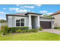 Charming one-story home showcasing a well-manicured lawn and a brick driveway leading to a two-car garage at 1740 Standing Rock Cir, Oakland, FL 34787