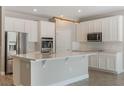 Modern kitchen with white cabinets, stainless steel appliances, and a large island with quartz countertops at 1740 Standing Rock Cir, Oakland, FL 34787