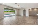 Open living room features tile flooring, natural light, and seamless access to the outdoor pool area at 1740 Standing Rock Cir, Oakland, FL 34787