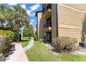 A view of the condo exterior with a sidewalk and lush tropical landscaping at 1908 Lake Atriums Cir # 3, Orlando, FL 32839